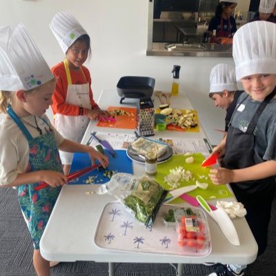 Four children preparing food at a table at a Grow Cook Eat WA Junior Kitchen workshop