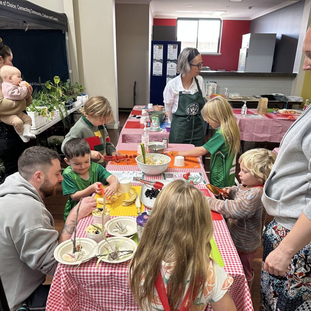 Children and parents preparing healthy recipes together at a Grow Cook Eat WA Family Kitchen workshop.