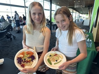 Children showing off creative edible fruit and vegetable faces made at a Grow Cook Eat WA event.